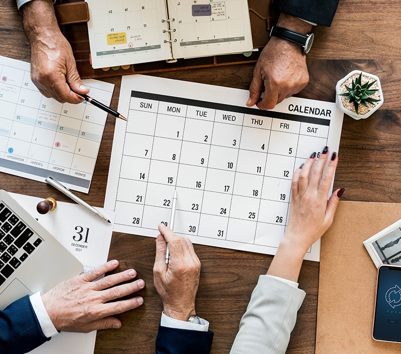 many hands on a desk calendar